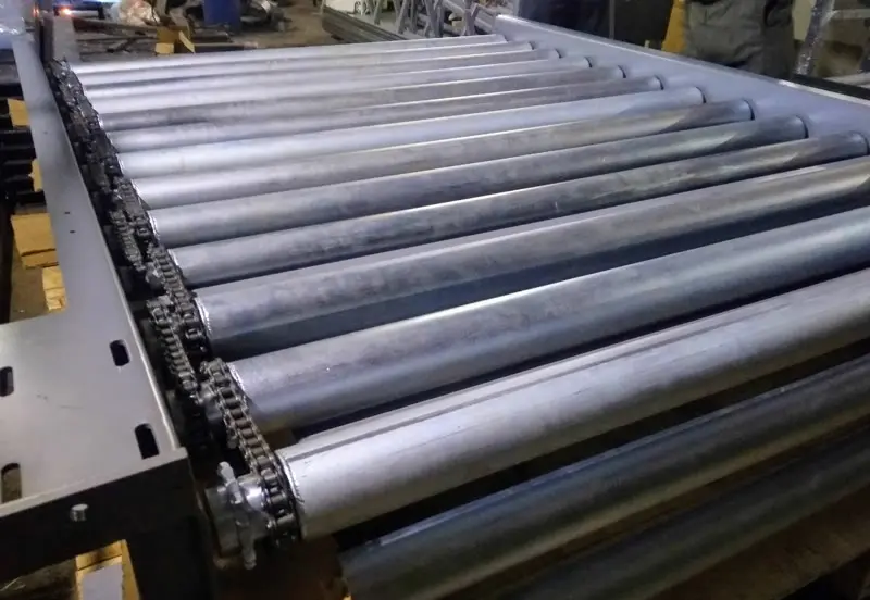 Technical visualization of chain-driven rollers and powered cross transfer mechanisms
